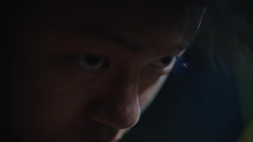 An asian male stares and looks focused