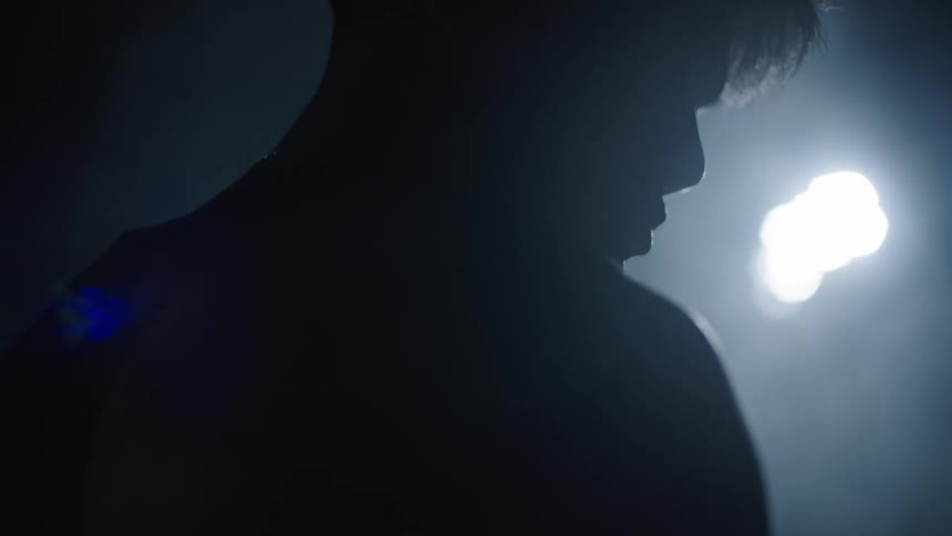A man walks in the dark through fog