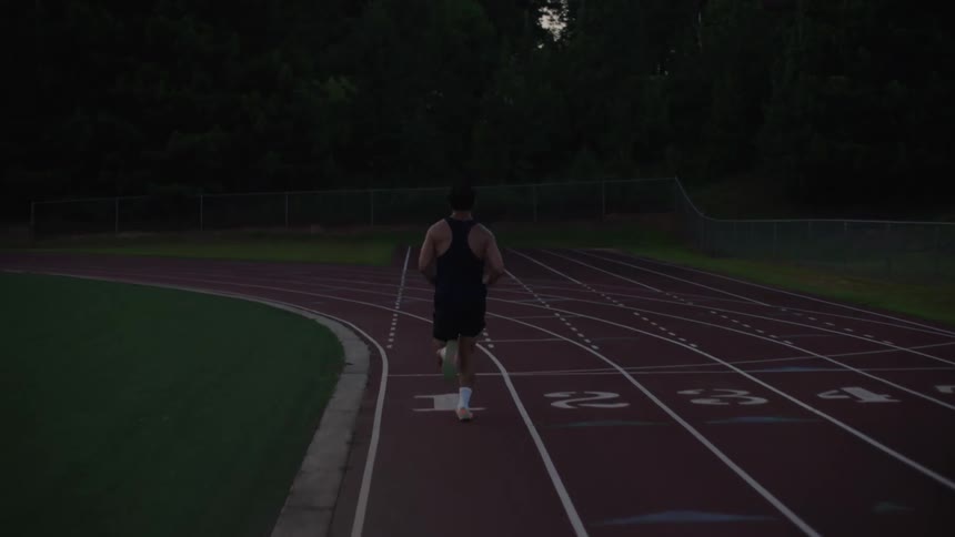 A male runs down the number one lane of a track