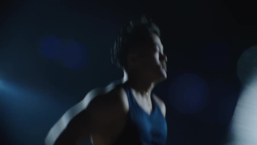 Man in tank top running at night