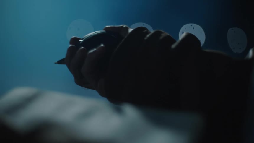 Person holding a clipboard and a stopwatch in an outdoor setting at night
