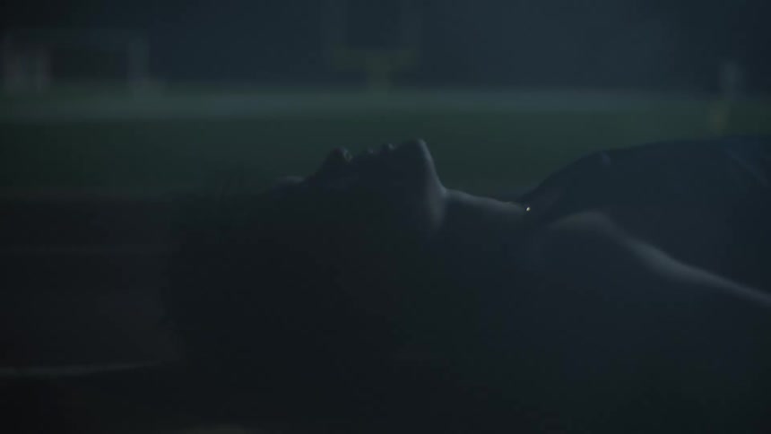 Man lying on a running track at night