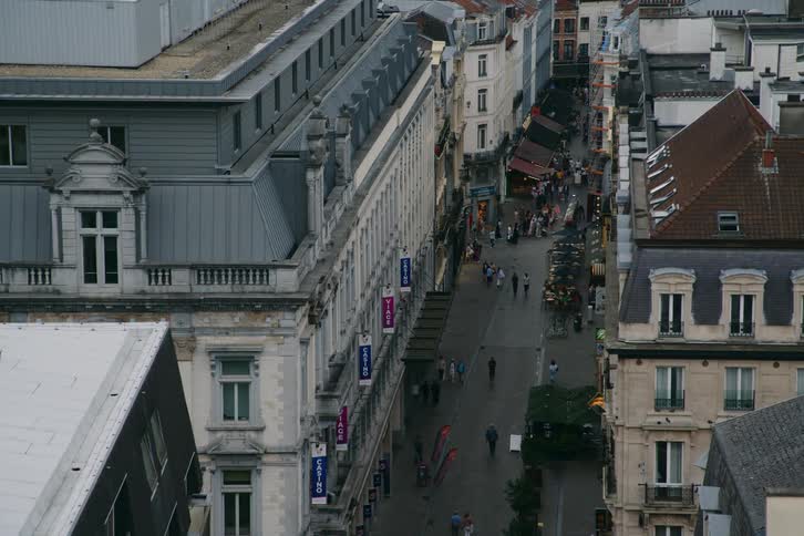 A bustling urban scene with classic european architecture busy sidewalks and cars parked along the road