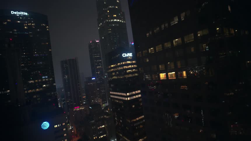 Aerial view of modern buildings and skyscrapers in a downtown metropolis illuminated at night