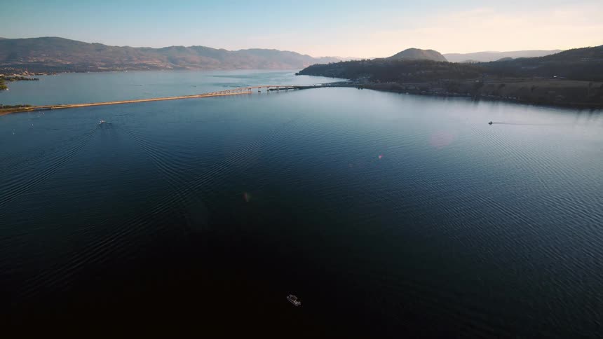 An aerial view of a bridge stretching across a calm lake