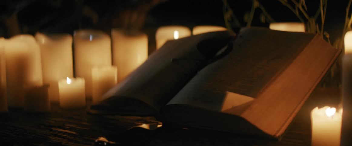Lit candles with an open book