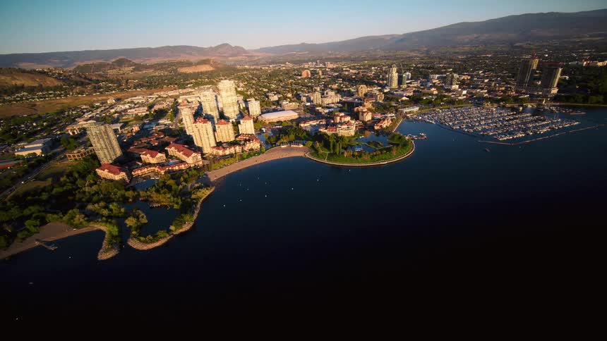 Aerial view of an urban city by the sea with mountains on the horizon