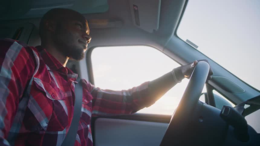 A man is driving and smiling