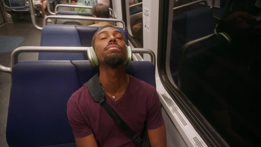 Man with headphones sleeping on a moving train