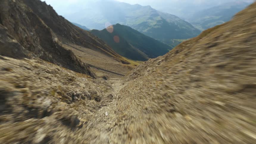 A narrow dirt path runs down the side of a large mountain