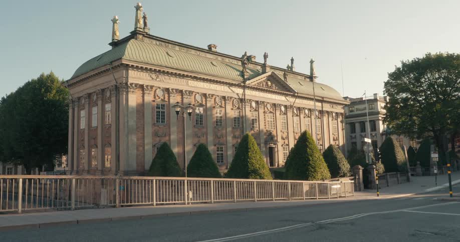 A large mansion sits behind fencing right off of a city street
