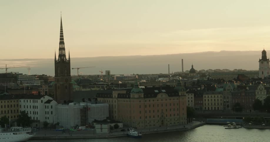 A church spire towers over a large coastal city
