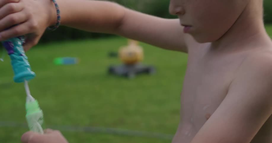 A child is blowing bubbles with a wand