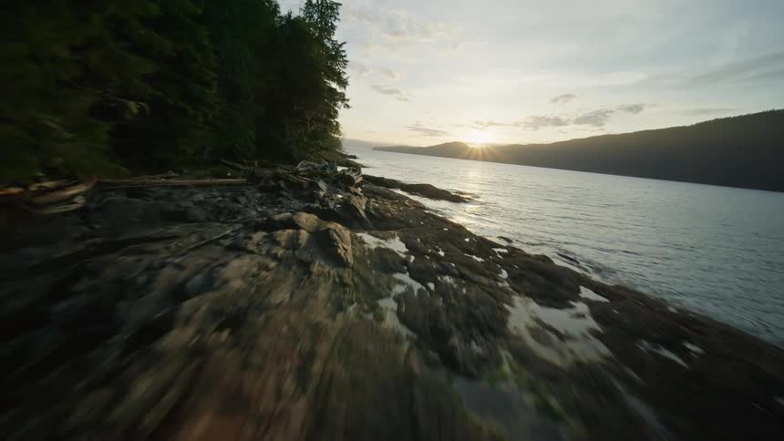 Flying over the edge of a forest river then turning right