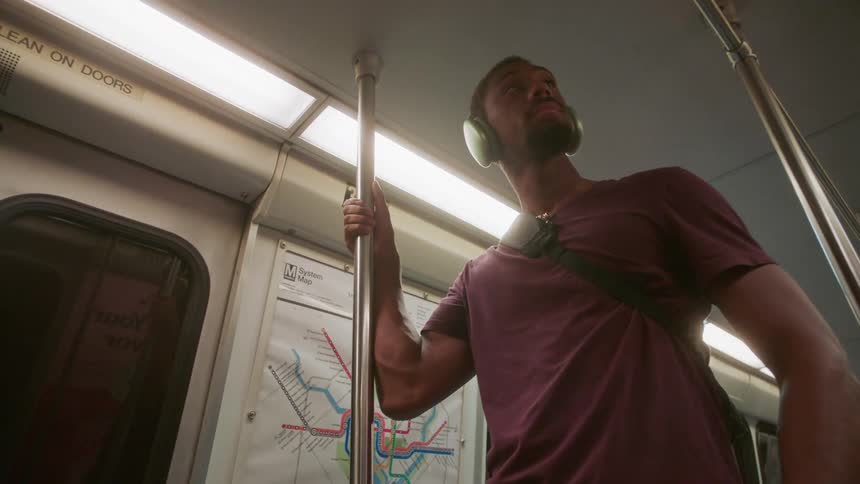 Man with headset standing on a moving train