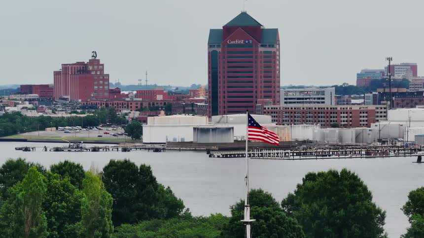 Aerial panorama of seaside geometropolis with us flag in foreground