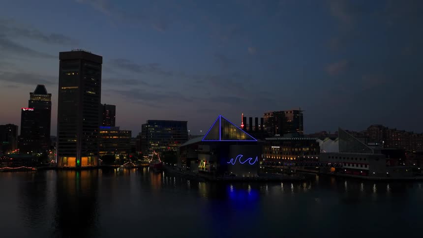 Aerial view of a modern metropolis illuminated at night and on the edge of a sea canal