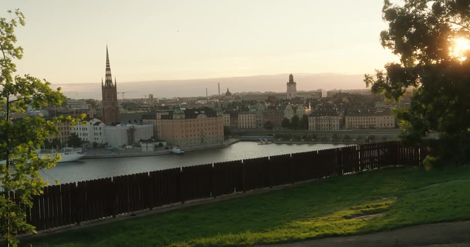 Landscape of an urban city with a tower in the background and the sun on the horizon