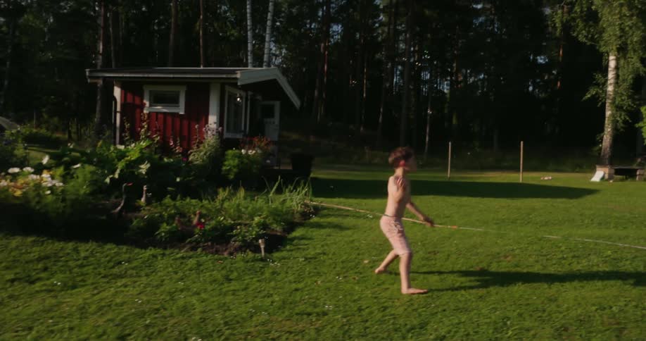 Boy jumping to catch bubbles in the yard