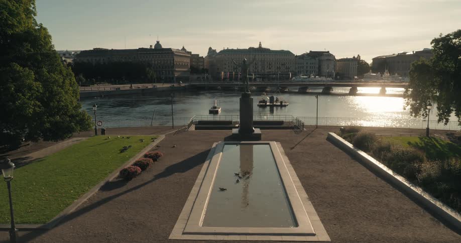 A statue is near the shore in the city