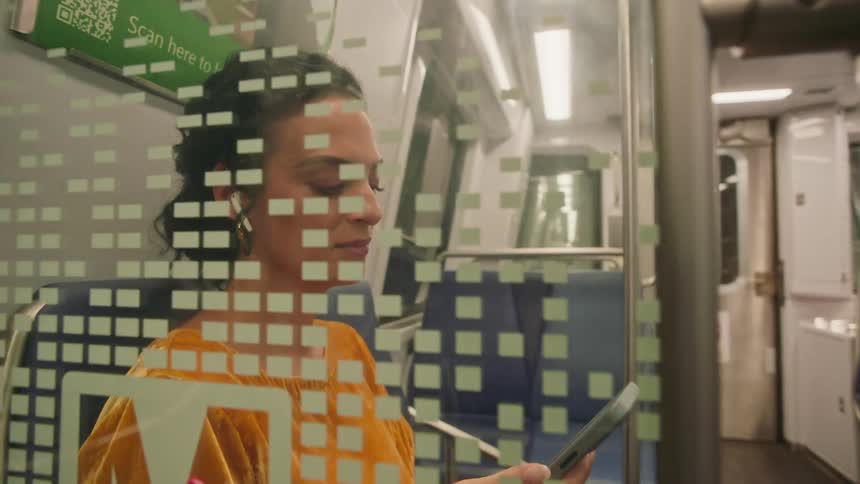 Woman sitting on a train interacting with a smartphone