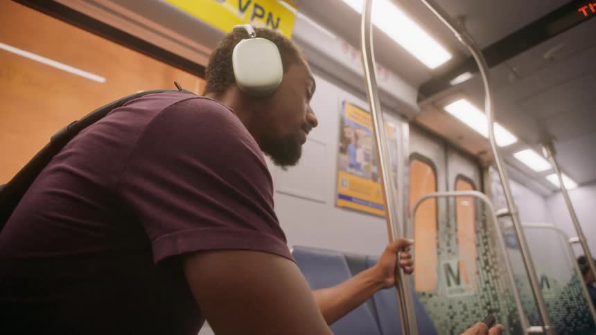 Man sitting with headphones inside a moving train