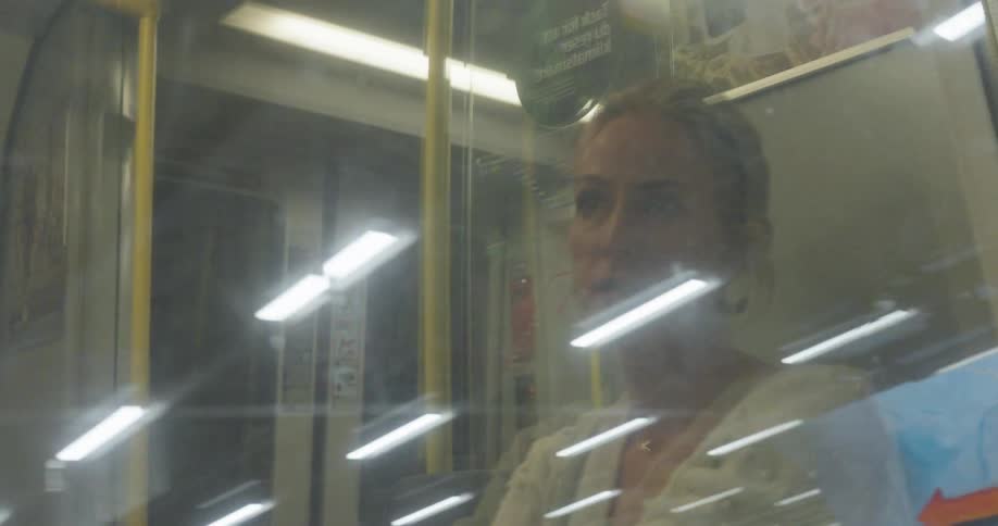 Woman talking while sitting on a subway that is moving quickly