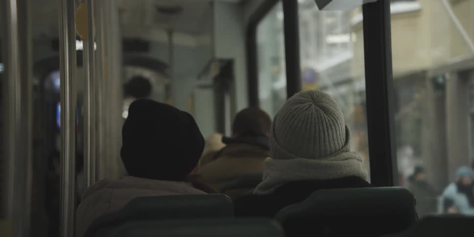 People inside a bus moving through the city in winter