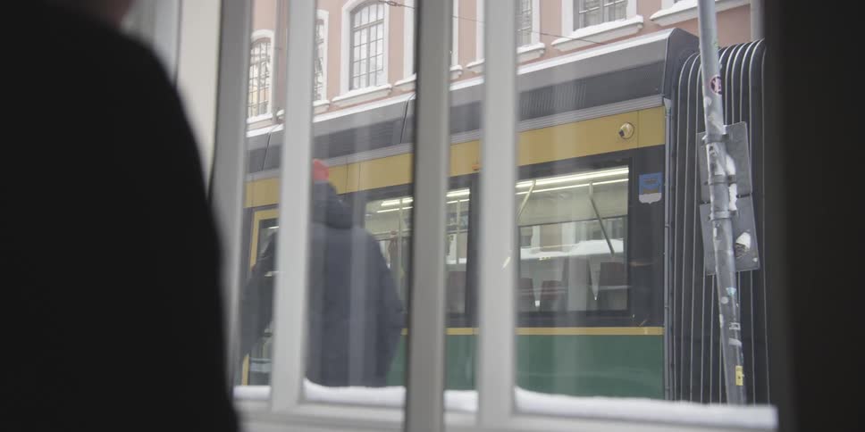 View from the window of an establishment with a bus stopped in the background and people passing by