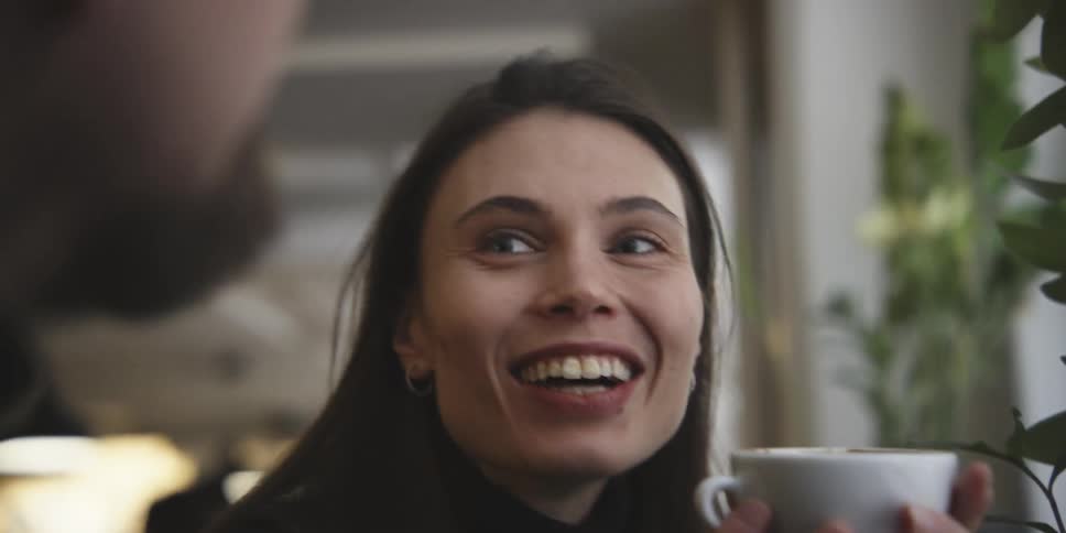 Man and woman in a coffee shop talking and drinking coffee
