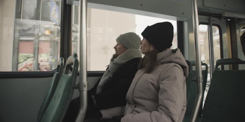 Two people talk while riding the bus