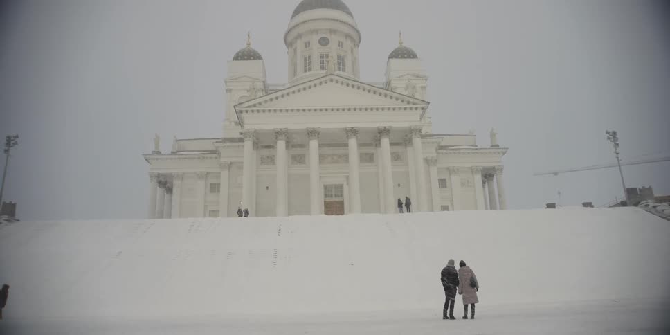 Couple holding hands walking in front of a temple on a snowy day