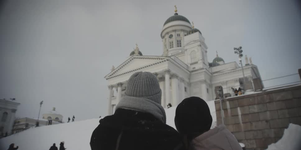A couple looking at a classical building on a snowy day