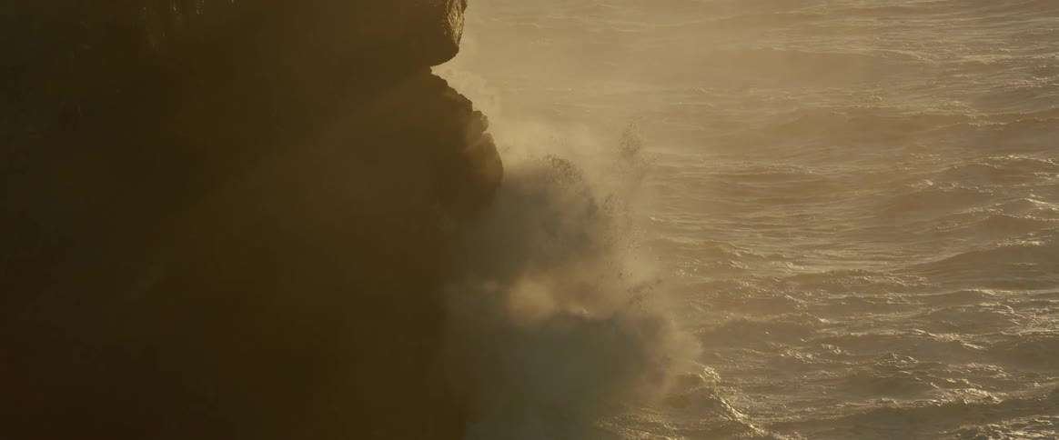 Strong ocean wave hitting the rocky wall of the coast