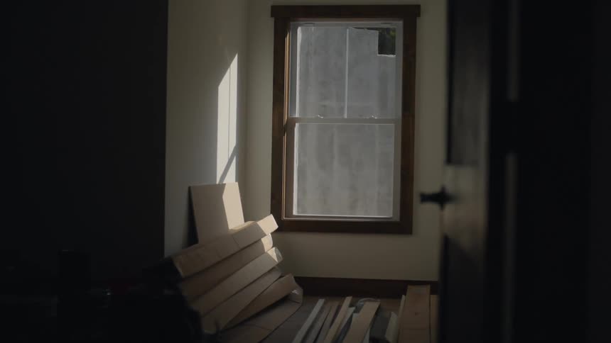 Looking into a rook with a bunch of wooden boards and a window