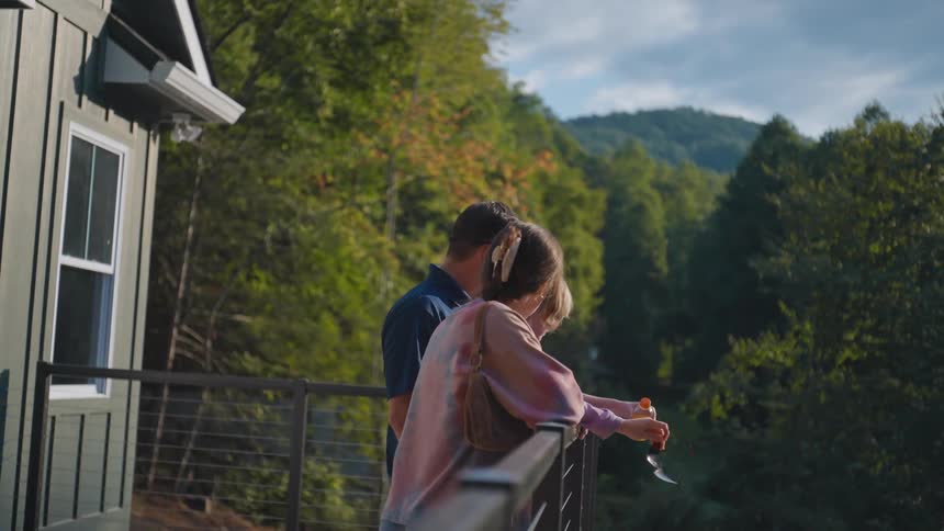 Family on the balcony of a house overlooking the forest