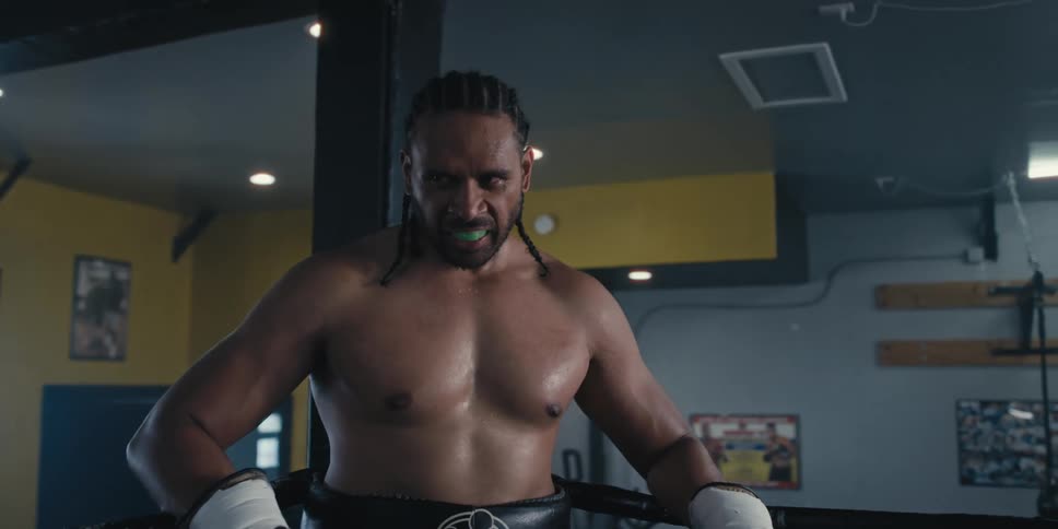 A boxer is breathing heavy in the ring