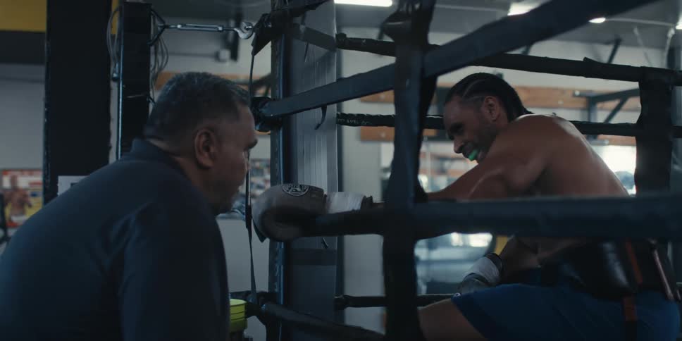 Trainer talking to a boxer who is inside a ring