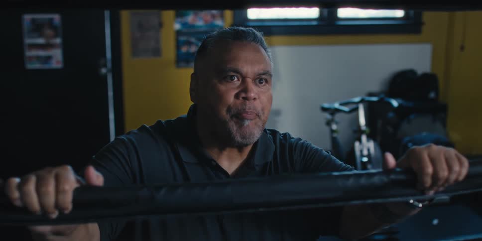 Man speaking harshly while standing outside a boxing ring