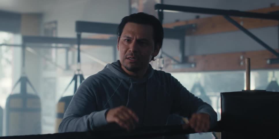 Boxing coach in a boxing gym gestures while providing training