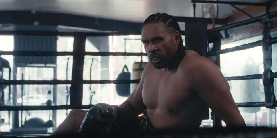 Man sitting with an angry expression in a boxing ring