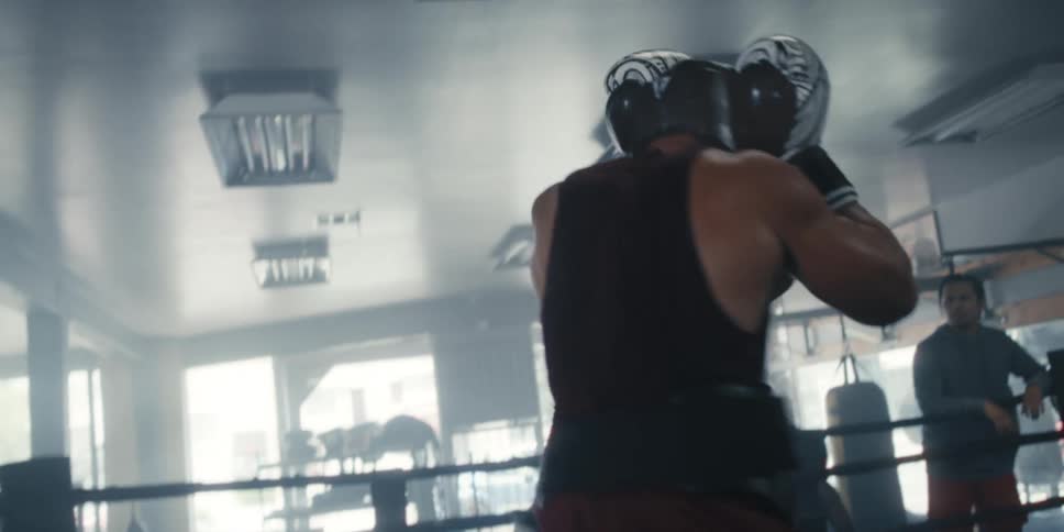 Man lifting another man while fighting in a boxing ring