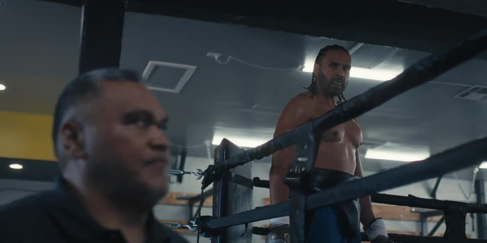 Man standing outside watching a boxer in the ring