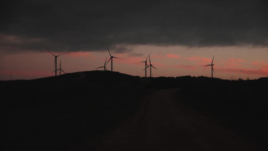 Windmills turn on a wind farm at dusk