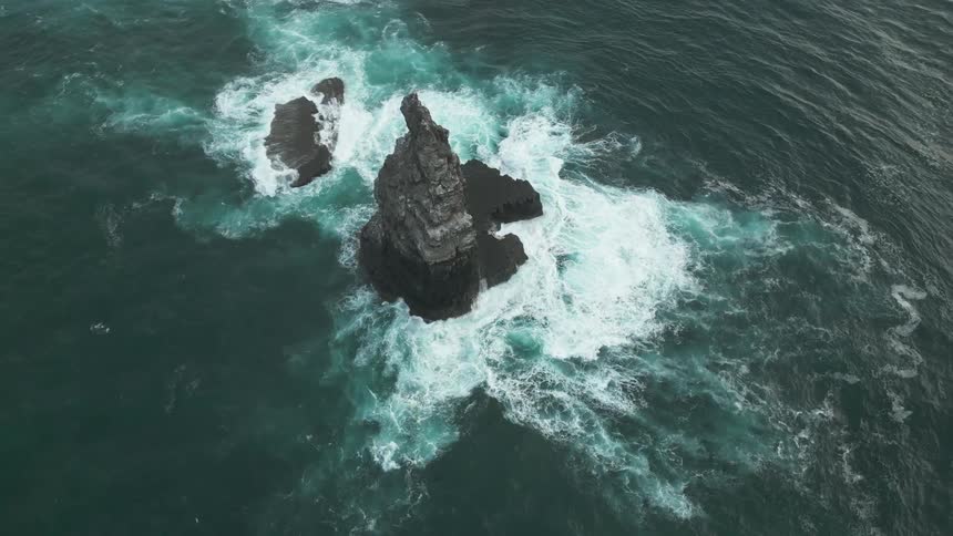 Aerial panorama of a cliff on a rock in the middle of the ocean