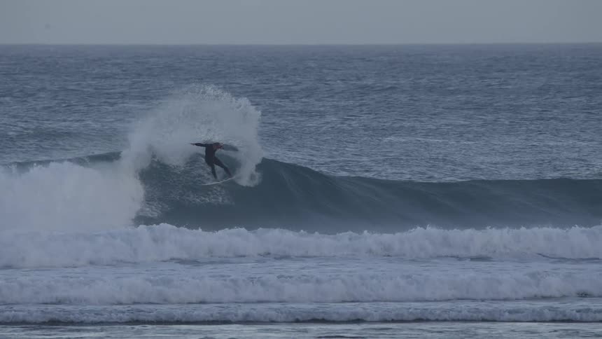 A man surfs an ocean wave before falling