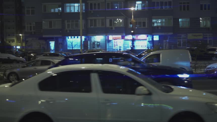 A car drives through town at night