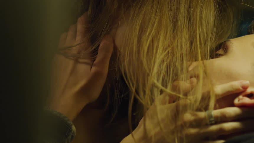 Close up of a young couple passionately kissing on a dimly lit room