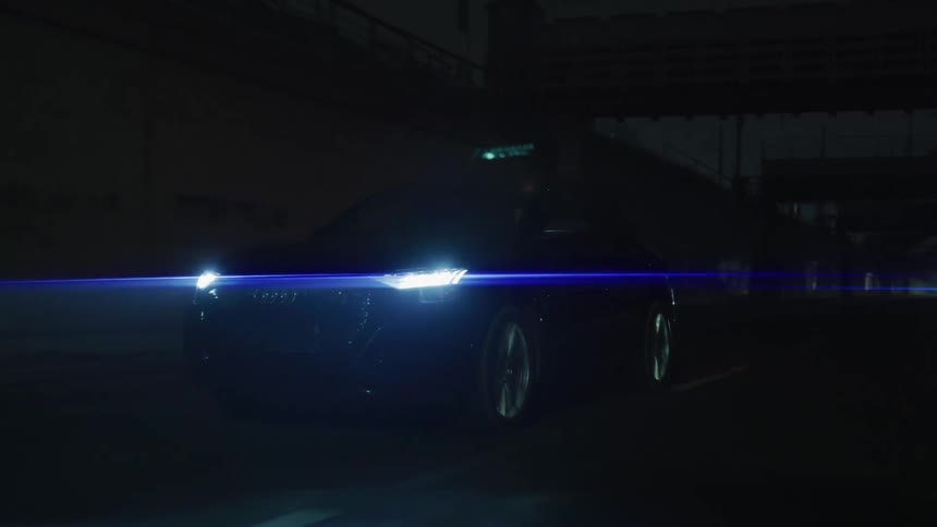 A car drives under the dark overpass