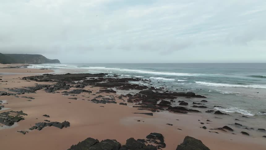 Rocks interrupt the waves at the beach